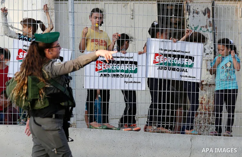 A female Israeli soldier stands guard during a demonstration by Palestinian protesters in the West Bank city of Hebron on September 18, 2017. Israel has given Jewish settlement enclaves in the occupied West Bank city of...