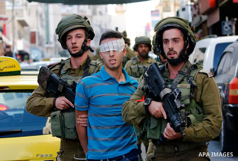 Israeli security forces detain a Palestinian youth after soldiers entered an area controlled by the Palestinian authority in the divided city of Hebron, in the Israeli-occupied West Bank, on September 20, 2017. Photo by...