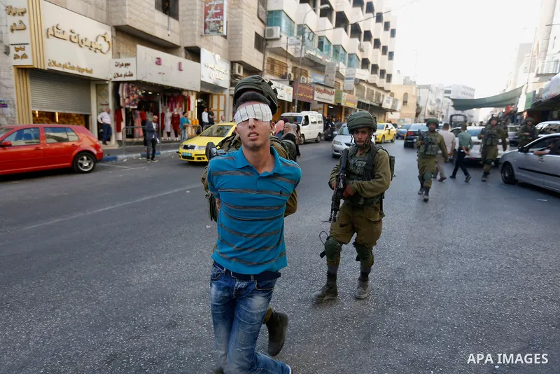 Israeli security forces detain a Palestinian youth after soldiers entered an area controlled by the Palestinian authority in the divided city of Hebron, in the Israeli-occupied West Bank, on September 20, 2017. Photo by...