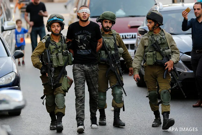 Israeli security forces detain a Palestinian youth after soldiers entered an area controlled by the Palestinian authority in the divided city of Hebron, in the Israeli-occupied West Bank, on September 20, 2017. Photo by...