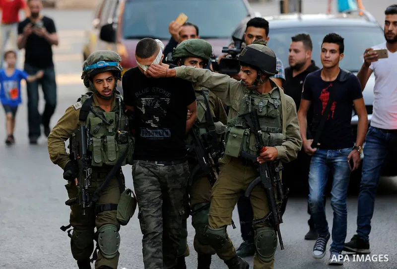 Israeli security forces detain a Palestinian youth after soldiers entered an area controlled by the Palestinian authority in the divided city of Hebron, in the Israeli-occupied West Bank, on September 20, 2017. Photo by...
