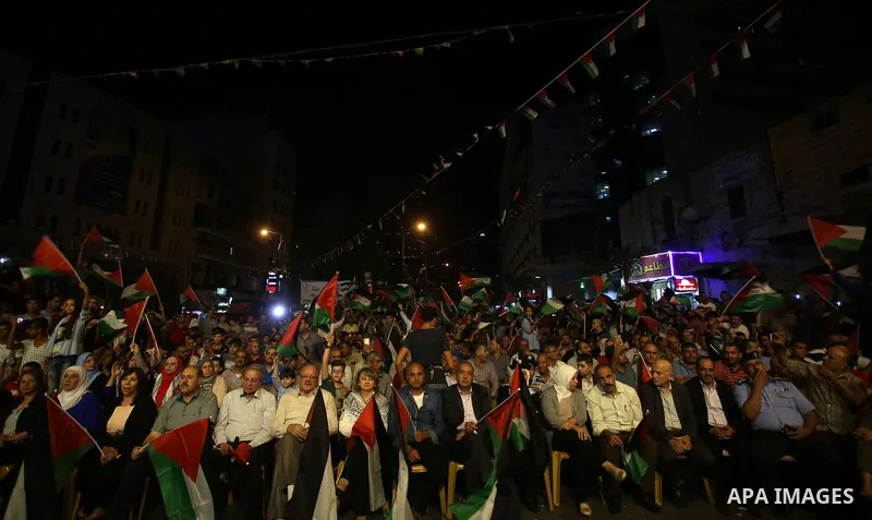 Palestinian supporters of Fateh movement watch the address of Palestinian President Mahmoud Abbas during the 72nd United Nations General Assembly at the United Nations headquarters in New York, in the West Bank city of N...