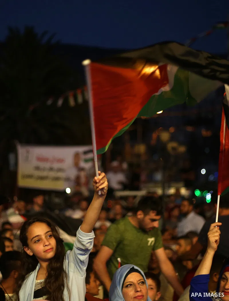 Palestinian supporters of Fateh movement watch the address of Palestinian President Mahmoud Abbas during the 72nd United Nations General Assembly at the United Nations headquarters in New York, in the West Bank city of N...