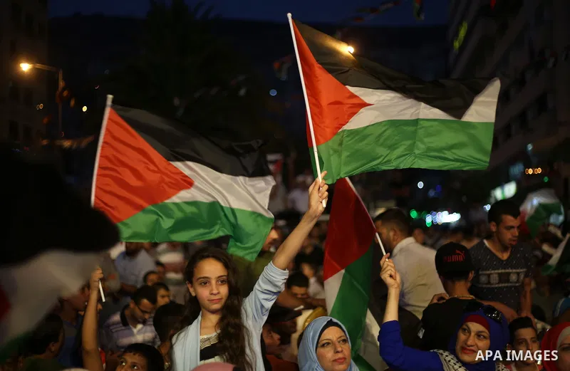 Palestinian supporters of Fateh movement watch the address of Palestinian President Mahmoud Abbas during the 72nd United Nations General Assembly at the United Nations headquarters in New York, in the West Bank city of N...