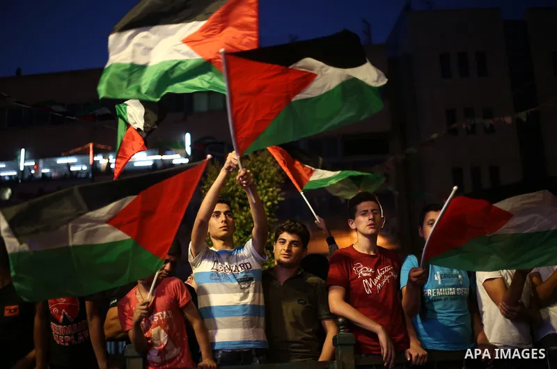 Palestinian supporters of Fateh movement watch the address of Palestinian President Mahmoud Abbas during the 72nd United Nations General Assembly at the United Nations headquarters in New York, in the West Bank city of N...