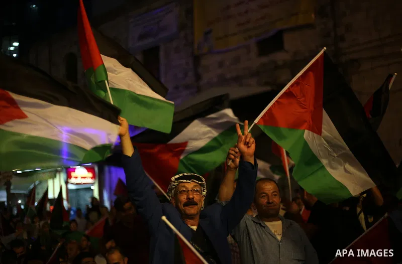 Palestinian supporters of Fateh movement watch the address of Palestinian President Mahmoud Abbas during the 72nd United Nations General Assembly at the United Nations headquarters in New York, in the West Bank city of N...