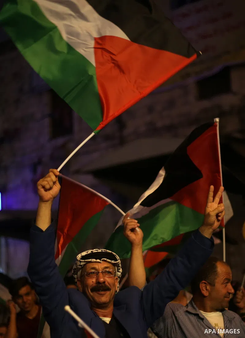 Palestinian supporters of Fateh movement watch the address of Palestinian President Mahmoud Abbas during the 72nd United Nations General Assembly at the United Nations headquarters in New York, in the West Bank city of N...