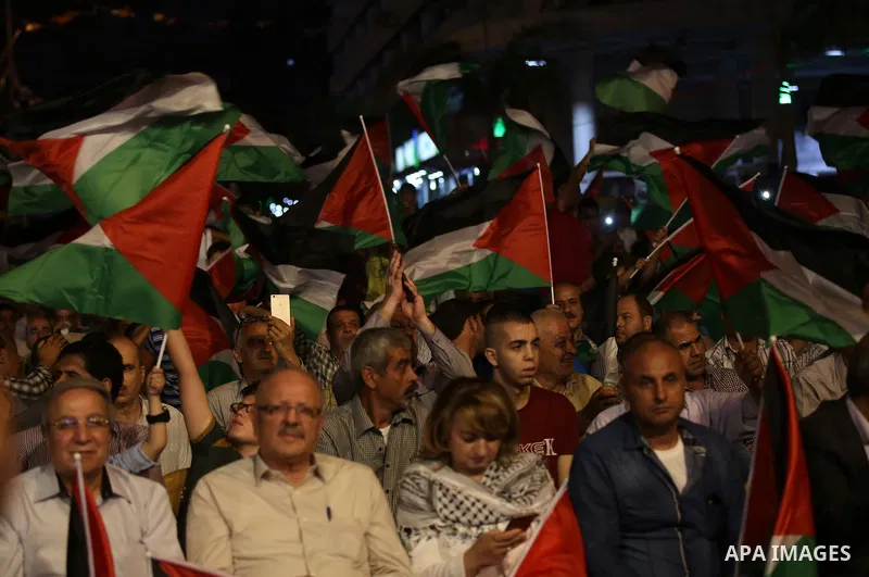 Palestinian supporters of Fateh movement watch the address of Palestinian President Mahmoud Abbas during the 72nd United Nations General Assembly at the United Nations headquarters in New York, in the West Bank city of N...