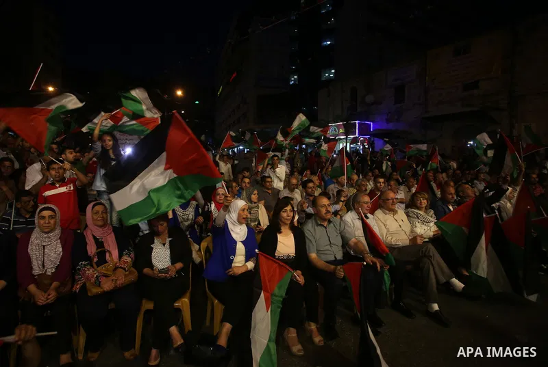 Palestinian supporters of Fateh movement watch the address of Palestinian President Mahmoud Abbas during the 72nd United Nations General Assembly at the United Nations headquarters in New York, in the West Bank city of N...