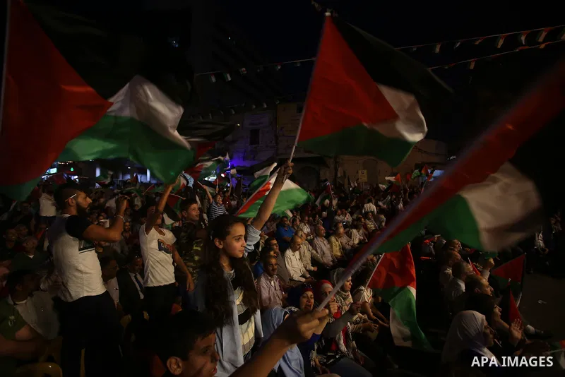 Palestinian supporters of Fateh movement watch the address of Palestinian President Mahmoud Abbas during the 72nd United Nations General Assembly at the United Nations headquarters in New York, in the West Bank city of N...