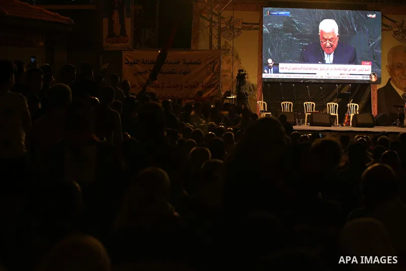Palestinian supporters of Fateh movement watch the address of Palestinian President Mahmoud Abbas during the 72nd United Nations General Assembly at the United Nations headquarters in New York, in the West Bank city of N...