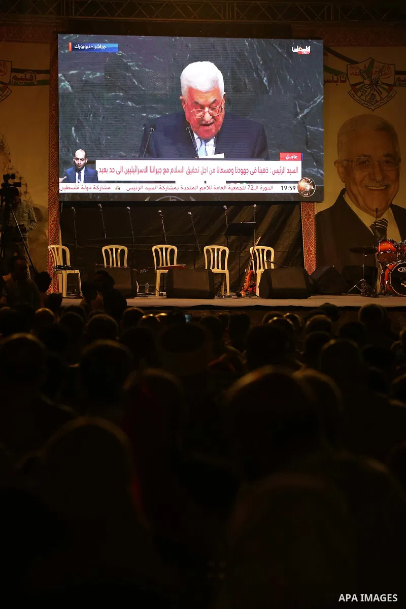Palestinian supporters of Fateh movement watch the address of Palestinian President Mahmoud Abbas during the 72nd United Nations General Assembly at the United Nations headquarters in New York, in the West Bank city of N...