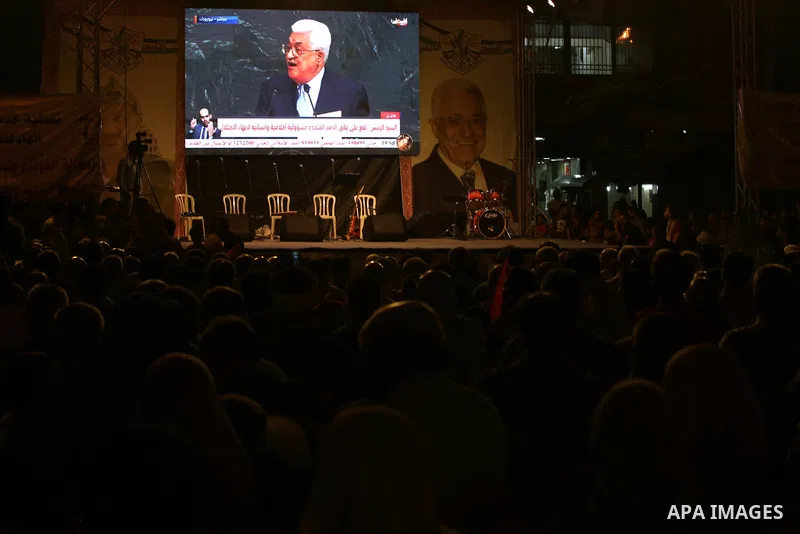 Palestinian supporters of Fateh movement watch the address of Palestinian President Mahmoud Abbas during the 72nd United Nations General Assembly at the United Nations headquarters in New York, in the West Bank city of N...