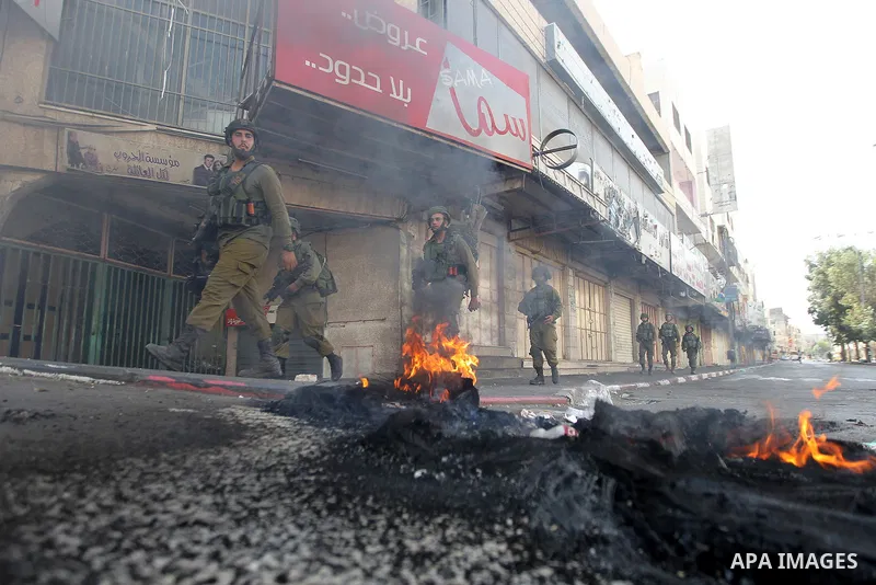 Israeli soldiers take position during a protest by Palestinians against closure of a road south of the West Bank city of Hebron September 22, 2017. Photo by Wisam Hashlamoun
