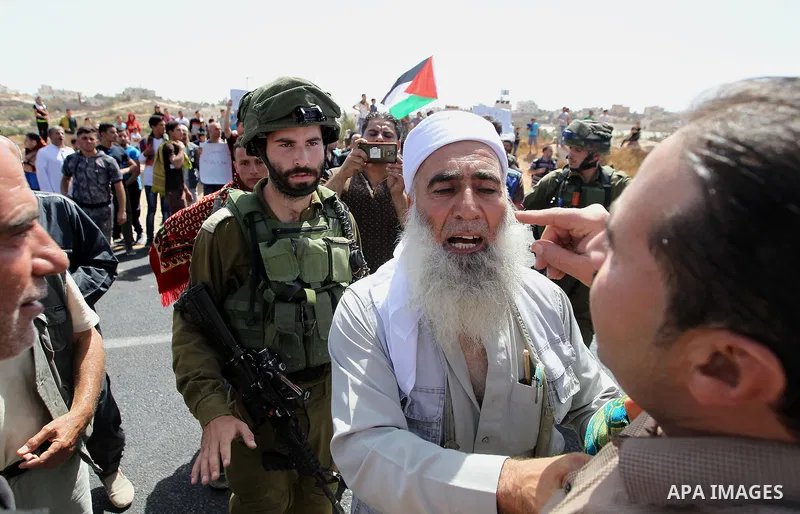 Palestinians take part in a protest against closure of a road by Israeli troops south of the West Bank city of Hebron September 22, 2017. Photo by Wisam Hashlamoun