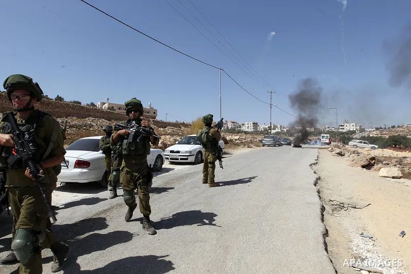 Israeli soldiers take position during a protest by Palestinians against closure of a road south of the West Bank city of Hebron September 22, 2017. Photo by Wisam Hashlamoun