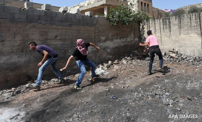 Palestinian protesters throw stones towards Israeli security forces during clashes following a demonstration against the expropriation of Palestinian land by Israel in the village of Kfar Qaddum, near Nablus in the occup...