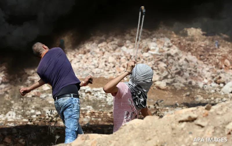 Palestinian protesters throw stones towards Israeli security forces during clashes following a demonstration against the expropriation of Palestinian land by Israel in the village of Kfar Qaddum, near Nablus in the occup...