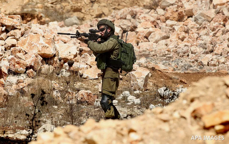 An Israeli soldier fires a tear gas canister during clashes following a demonstration against the expropriation of Palestinian land by Israel in the village of Kfar Qaddum, near Nablus in the occupied West Bank, on Septe...