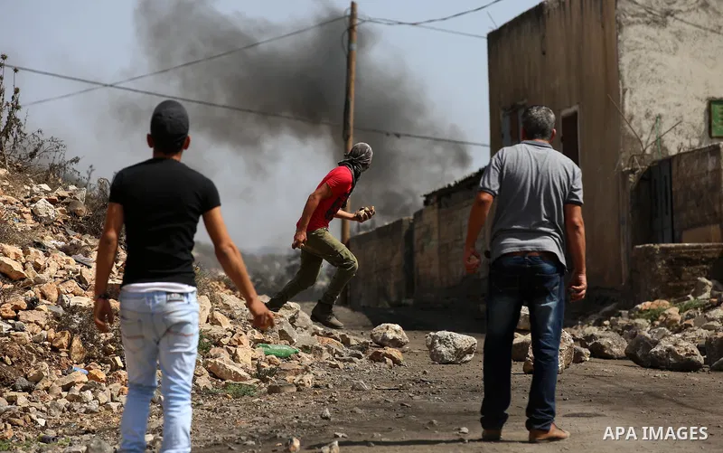Palestinian protesters throw stones towards Israeli security forces during clashes following a demonstration against the expropriation of Palestinian land by Israel in the village of Kfar Qaddum, near Nablus in the occup...