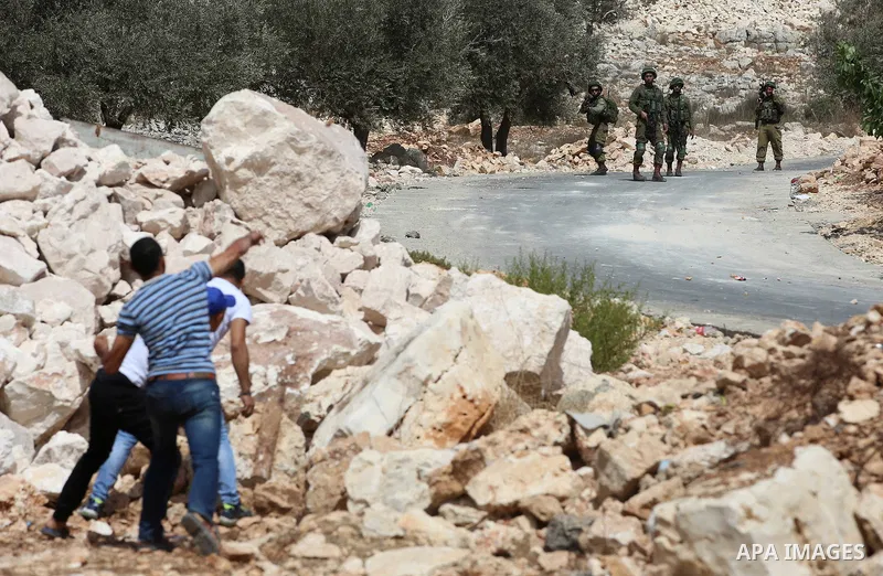 Palestinian protesters throw stones towards Israeli security forces during clashes following a demonstration against the expropriation of Palestinian land by Israel in the village of Kfar Qaddum, near Nablus in the occup...