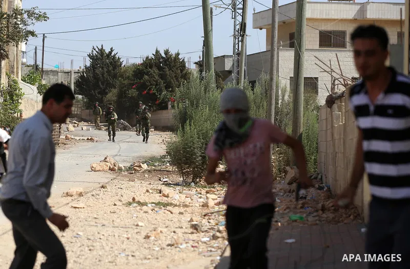 Palestinian protesters throw stones towards Israeli security forces during clashes following a demonstration against the expropriation of Palestinian land by Israel in the village of Kfar Qaddum, near Nablus in the occup...