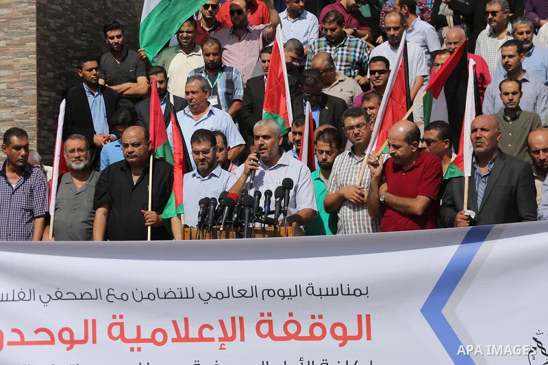 Palestinian journalists take part in a rally to support of the Palestinian reconciliation, in front of the legislative council in Gaza city, on September 26, 2017. Photo by Mohammed Asad