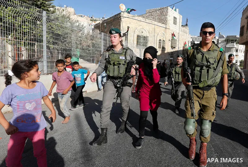 Israeli security forces detain a Palestinian girl after she allegedly tried to cross a checkpoint with a knife, near the Ibrahimi mosque, or the Tomb of the Patriarch in the West Bank city of Heborn on September 27, 2017...