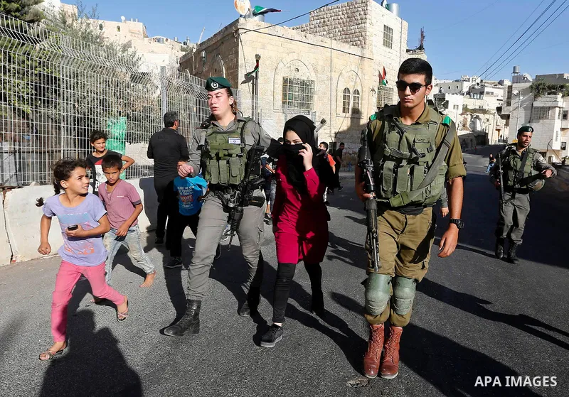 Israeli security forces detain a Palestinian girl after she allegedly tried to cross a checkpoint with a knife, near the Ibrahimi mosque, or the Tomb of the Patriarch in the West Bank city of Heborn on September 27, 2017...