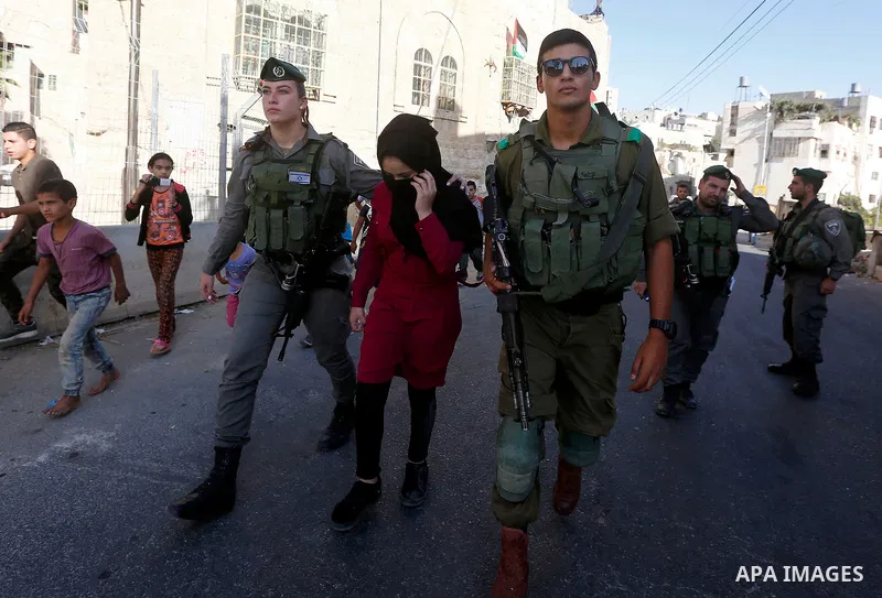 Israeli security forces detain a Palestinian girl after she allegedly tried to cross a checkpoint with a knife, near the Ibrahimi mosque, or the Tomb of the Patriarch in the West Bank city of Heborn on September 27, 2017...