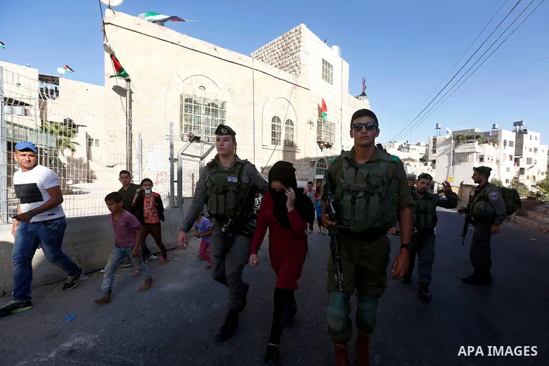 Israeli security forces detain a Palestinian girl after she allegedly tried to cross a checkpoint with a knife, near the Ibrahimi mosque, or the Tomb of the Patriarch in the West Bank city of Heborn on September 27, 2017...