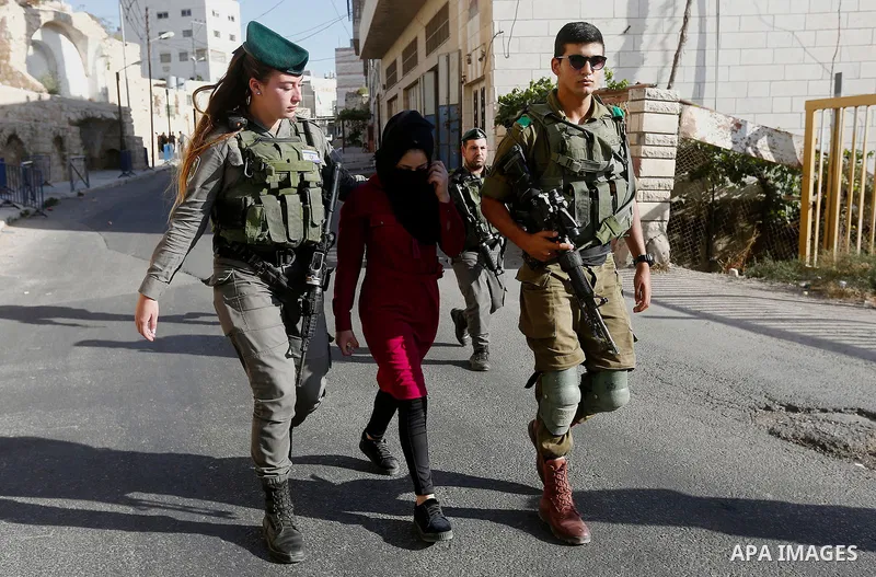 Israeli security forces detain a Palestinian girl after she allegedly tried to cross a checkpoint with a knife, near the Ibrahimi mosque, or the Tomb of the Patriarch in the West Bank city of Heborn on September 27, 2017...