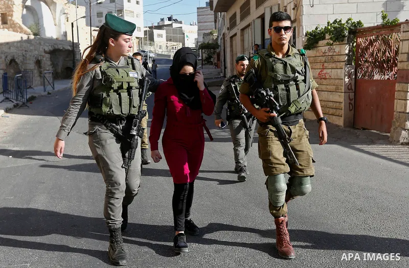 Israeli security forces detain a Palestinian girl after she allegedly tried to cross a checkpoint with a knife, near the Ibrahimi mosque, or the Tomb of the Patriarch in the West Bank city of Heborn on September 27, 2017...