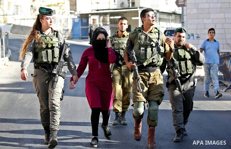 Israeli security forces detain a Palestinian girl after she allegedly tried to cross a checkpoint with a knife, near the Ibrahimi mosque, or the Tomb of the Patriarch in the West Bank city of Heborn on September 27, 2017...