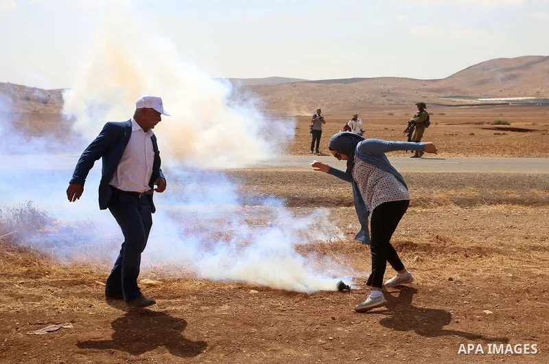 Palestinian protesters react to tear gas fired by Israeli security forces during clashes following a protest against the expropriation of Palestinian land in the village of Atouf, near the west bank city of Tubas on Sept...