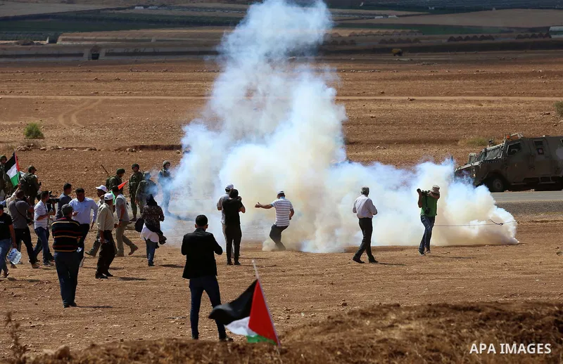 Palestinian protesters react to tear gas fired by Israeli security forces during clashes following a protest against the expropriation of Palestinian land in the village of Atouf, near the west bank city of Tubas on Sept...