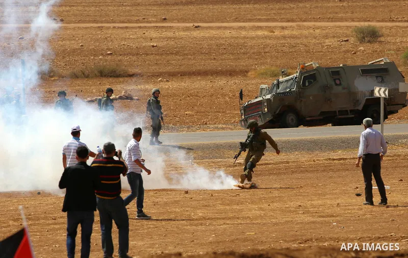Palestinian protesters react to tear gas fired by Israeli security forces during clashes following a protest against the expropriation of Palestinian land in the village of Atouf, near the west bank city of Tubas on Sept...