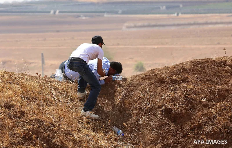 Palestinian protesters take cover from tear gas fired by Israeli security forces during clashes following a protest against the expropriation of Palestinian land in the village of Atouf, near the west bank city of Tubas...