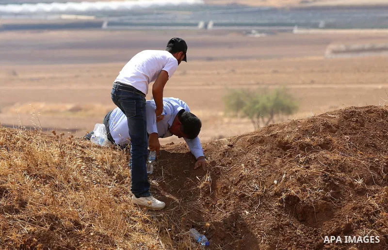 Palestinian protesters take cover from tear gas fired by Israeli security forces during clashes following a protest against the expropriation of Palestinian land in the village of Atouf, near the west bank city of Tubas...