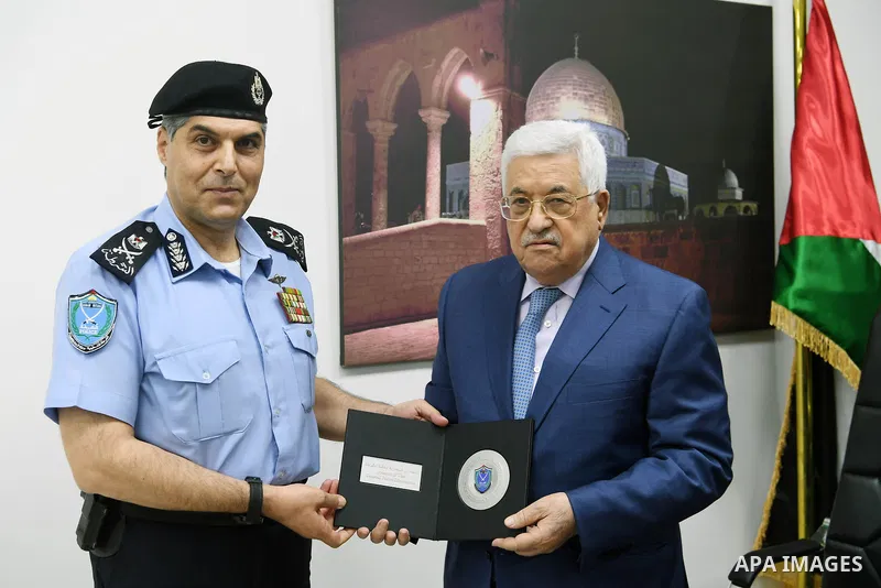 Palestinian President Mahmoud Abbas recives the shield of Palestinian police on the occasion of Palestine's accession to the International Police Organization (Interpol) in the West Bank city of Ramallah on September 27,...