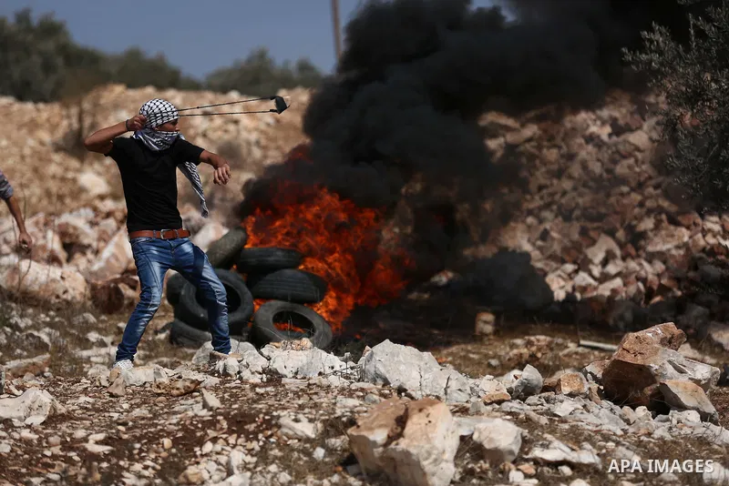 A Palestinian protester burns tires during clashes with Israeli troops near the Jewish settlement of Qadomem, in the West Bank village of Kofr Qadom near Nablus September 29, 2017. Photo by Ayman Ameen