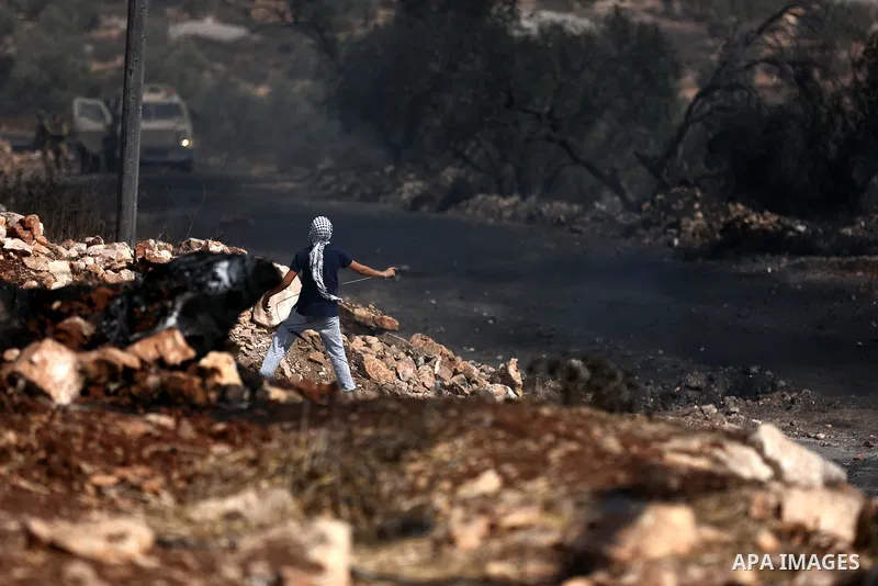 A Palestinian protester hurls stones towards Israeli troops during clashes near the Jewish settlement of Qadomem, in the West Bank village of Kofr Qadom near Nablus September 29, 2017. Photo by Ayman Ameen