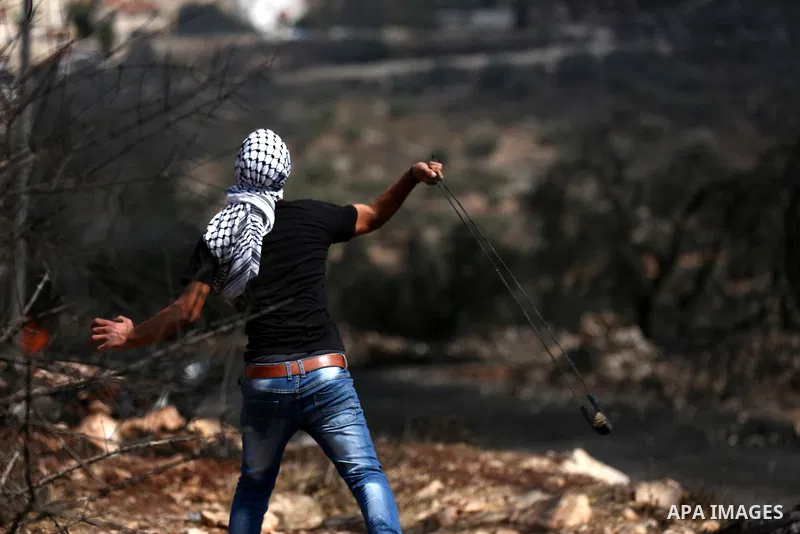 A Palestinian protester hurls stones towards Israeli troops during clashes near the Jewish settlement of Qadomem, in the West Bank village of Kofr Qadom near Nablus September 29, 2017. Photo by Ayman Ameen