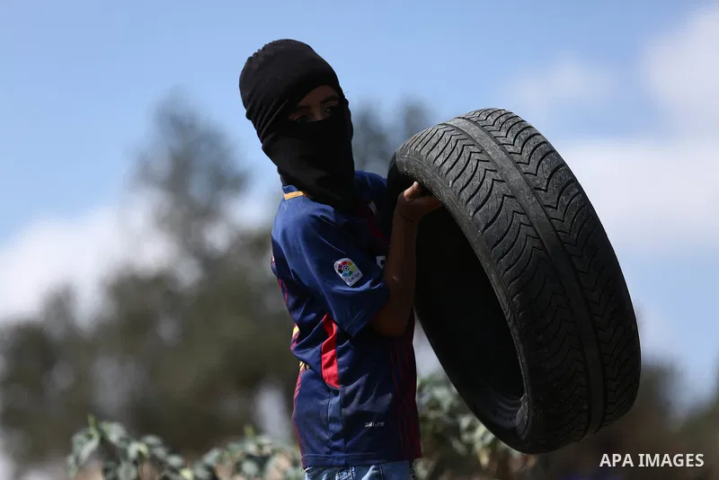 A Palestinian protester burns tires during clashes with Israeli troops near the Jewish settlement of Qadomem, in the West Bank village of Kofr Qadom near Nablus September 29, 2017. Photo by Ayman Ameen