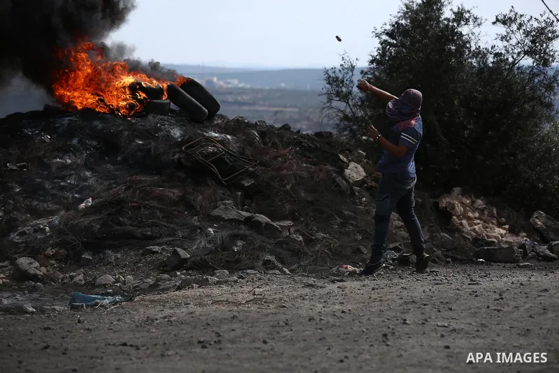 A Palestinian protester hurls stones towards Israeli troops during clashes near the Jewish settlement of Qadomem, in the West Bank village of Kofr Qadom near Nablus September 29, 2017. Photo by Ayman Ameen