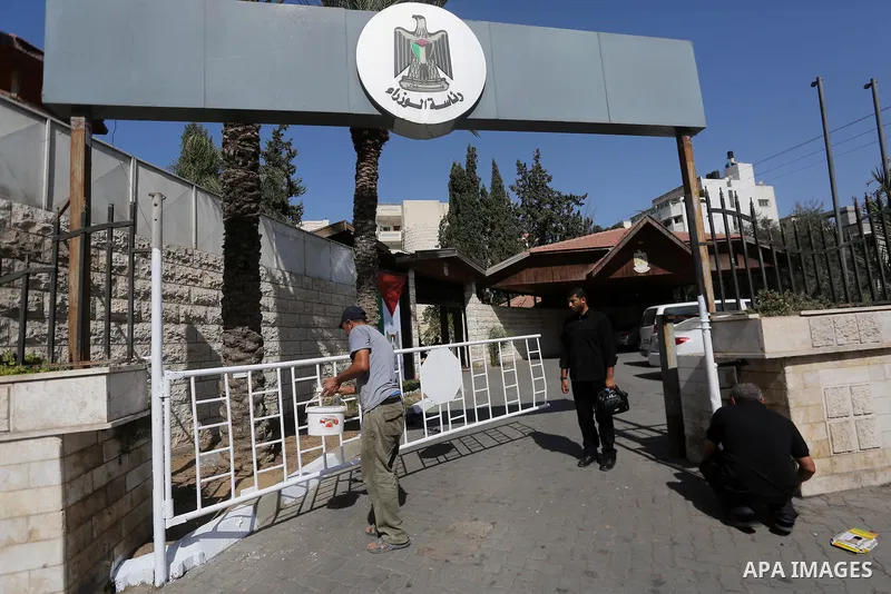 Palestinian workers clean outside the Palestinian cabinet headquarters in Gaza City on October 1, 2017. Photo by Mohammed Asad