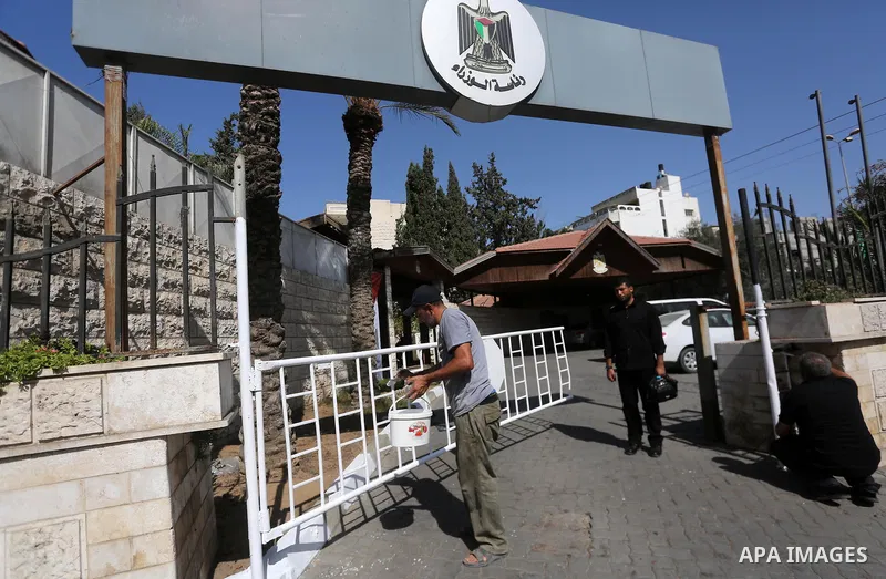 Palestinian workers clean outside the Palestinian cabinet headquarters in Gaza City on October 1, 2017. Photo by Mohammed Asad