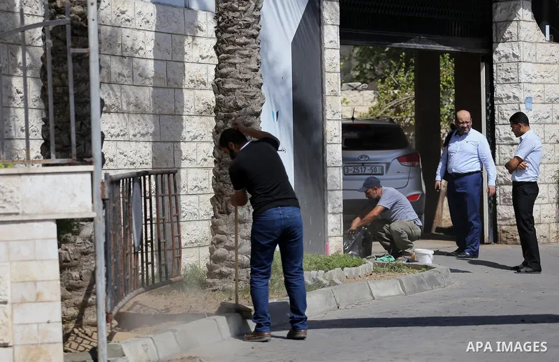 Palestinian workers clean outside the Palestinian cabinet headquarters in Gaza City on October 1, 2017. Photo by Mohammed Asad