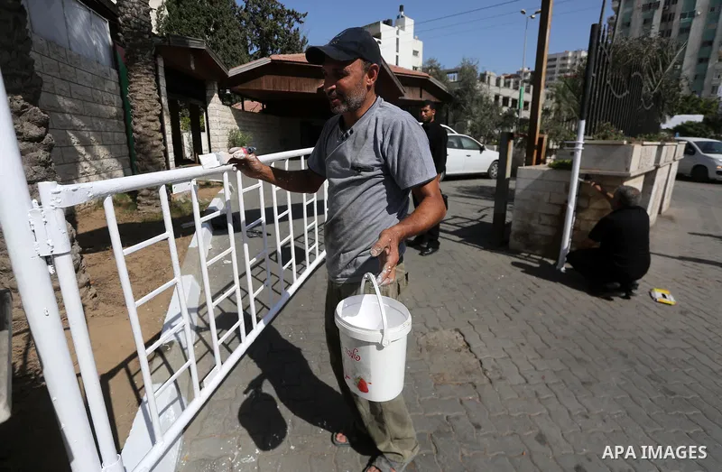 Palestinian workers clean outside the Palestinian cabinet headquarters in Gaza City on October 1, 2017. Photo by Mohammed Asad
