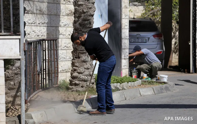 Palestinian workers clean outside the Palestinian cabinet headquarters in Gaza City on October 1, 2017. Photo by Mohammed Asad